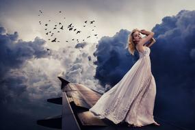 Woman in long Dress on wing of Aircraft at clouds, collage