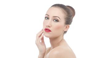 Portrait of the woman, with red lips, hairstyle and shiny skin, at white background