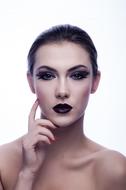 Portrait of the girl, with the dark make-up, at white background