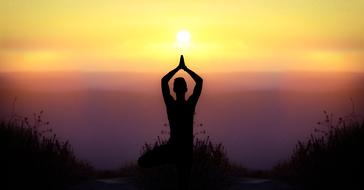 silhouette of a girl during yoga at sunset