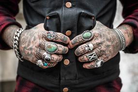 hands in tattoos and rings