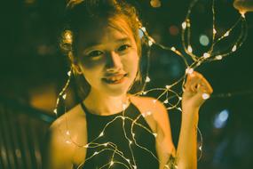 happy girl with light garland in the dark