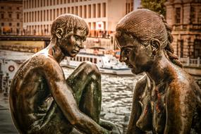 bronze statues of sitting boy and girl