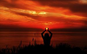 woman doing yoga exercises at sunset