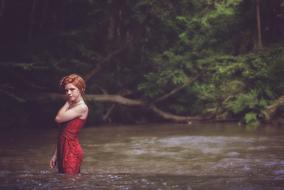 Girl in red river forest