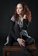 Posing sitting woman on the dark background