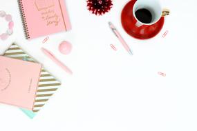 pink notebooks and a cup of coffee on the table