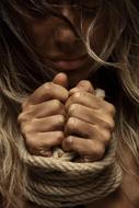 hands of young girl banded with rope