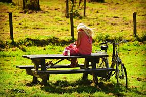 Woman Sitts on wooden table outdoor