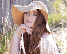 woman with wide hat on long hair in summer