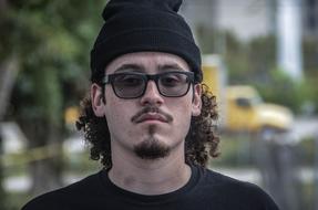 portrait of a young man with glasses on a blurred background