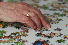 Puzzling Hobby, hand of an elderly woman