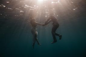 couple in water holding hands