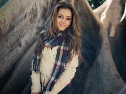 smiling young woman with long hair in nature