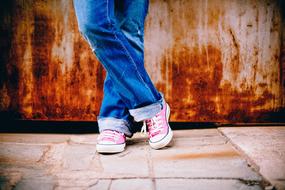 crossed legs near old rusty wall