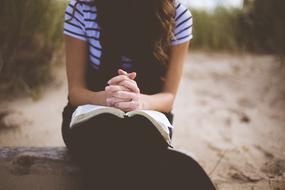 girl reading book on the beach