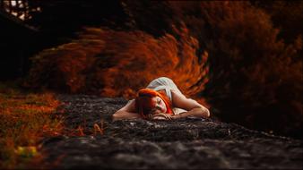 autumn photo shoot red-haired girl lies on the grass