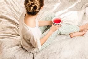 woman with a cup in bed