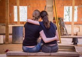 two girlfriends discuss room repair plan