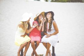 three pretty girls sitting on Bench on beach, Friendship