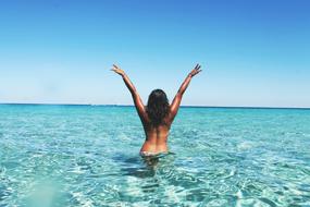 tanned girl standing in sea