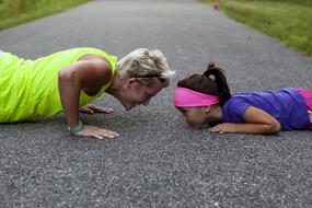 mom and daughter push up on the pavement