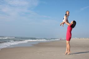 mom raised her son in her arms by the sea