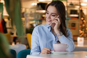 girl talking on the phone sitting in a cafe