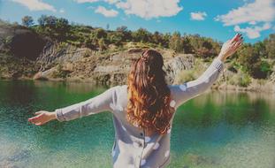 back view of long hair Woman in front of water