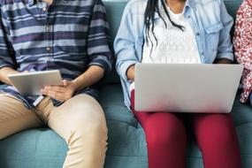 People, using laptop and tablet, while sitting on the sofa