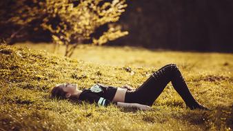 Girl is lying on the grass on the landscape
