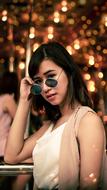 Woman with glasses, posing, at beautiful background with colorful bokeh lights