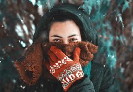 girl closes her mouth with a scarf