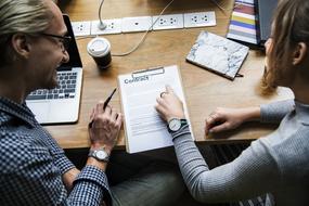 People in collaboration, working with the papers, on the table