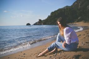 girl sits on beach at Blue Ocean