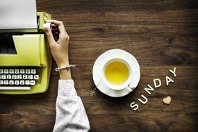 yellow typewriter and cup with green tea on the table