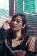 Portrait of the beautiful Asian girl, with the shadow of the window shutters, with light