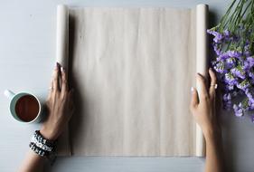 girl unwinds wrapping paper on the table