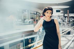 beautiful Brunette Woman posing in mall on bright background with the shops