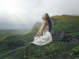 woman in white sundress among green mountains