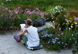 girl artist paints in the garden
