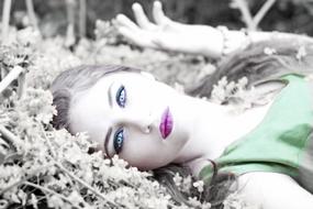 Girl lays on her back among Flowers