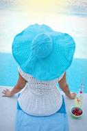 girl in a white dress and blue hat view from the back