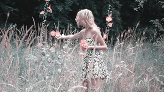 Girl is collecting flowers on the field, monochrome