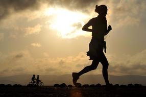 Silhouette of the runner under the sunshine