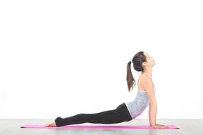 woman in yoga pose on pink mat