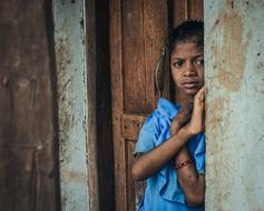 girl near dilapidated building in india