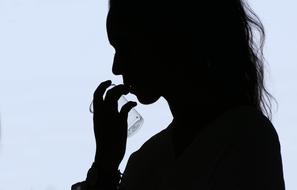 Dark silhouette of a woman with the glass