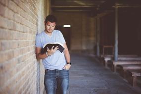 Adult reading a Book near the wall