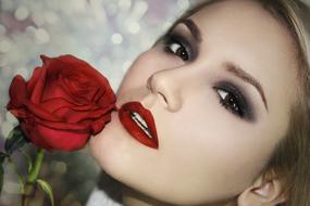 girl with bright makeup and a red rose